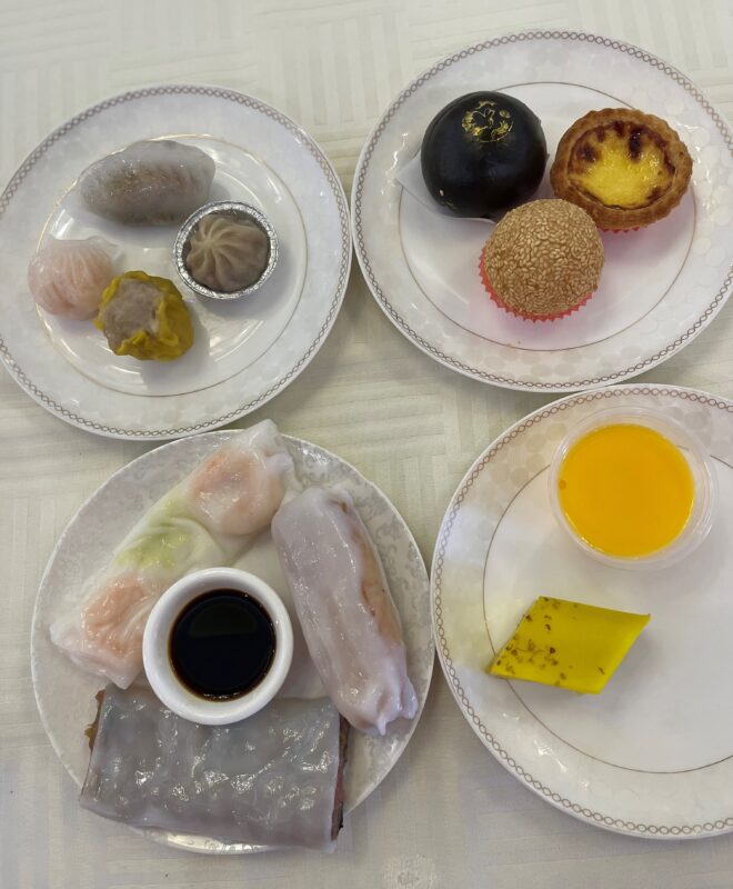 dim sum items on white plates set on a gray table cloth from Tong Tak Restaurant