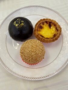 sesame ball dim sum items on a plate with a silve rim