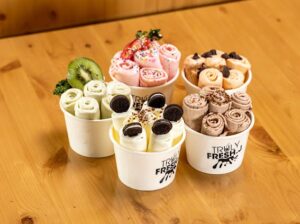 Truly Fresh J rolled ice cream in containers with fruits and toppings 